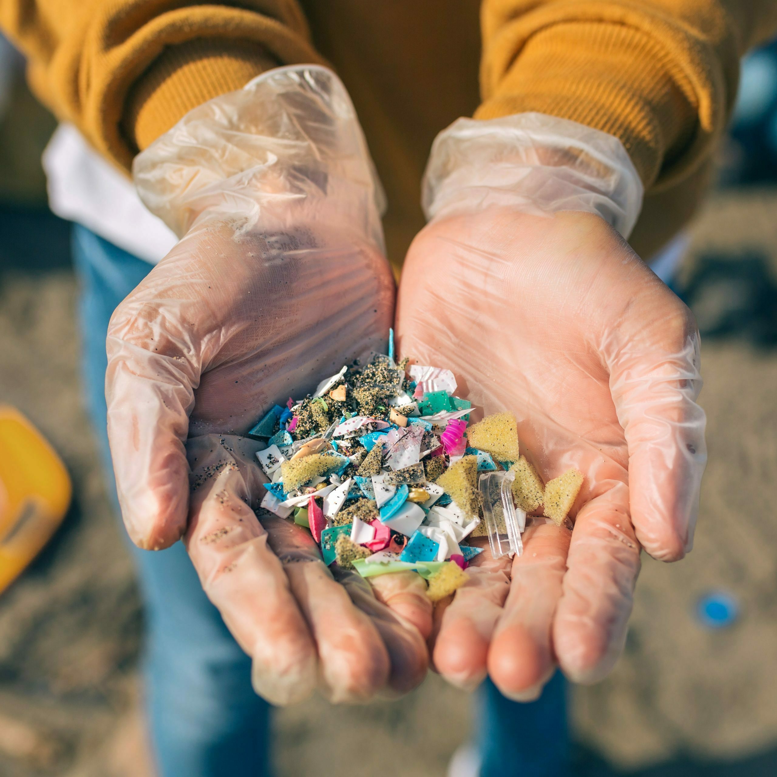 Hands holding microplastics on the beach Detail of hands showing microplastics on the beach